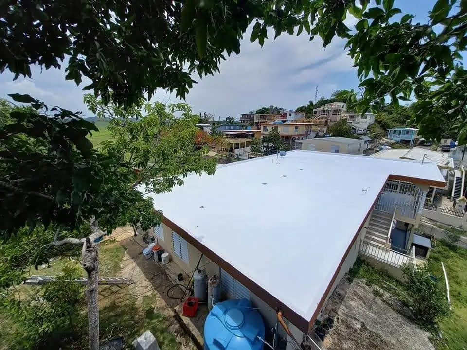 Vista aérea en ángulo — Techo sellado en barrio de ladera.