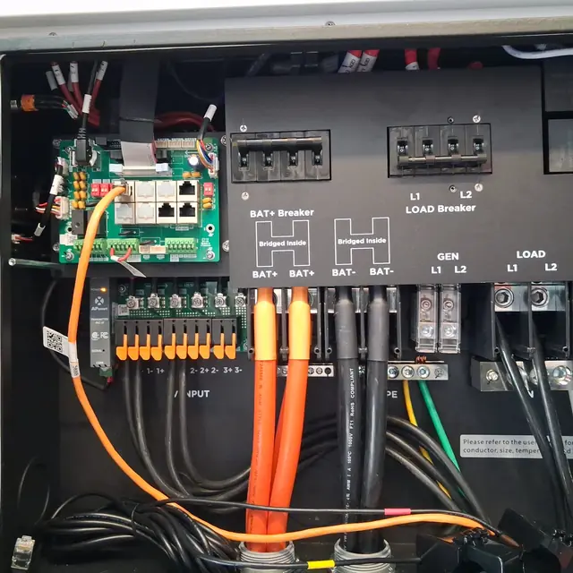 Interior del inversor — Cableado de batería, carga y red, rotulado.